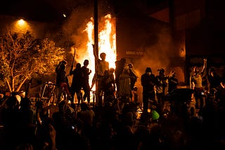 Protestors stand before a burning Third Police Precinct building in Minneapolis after the death of George Floyd.