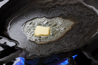 Butter melting in a cast iron pan. A melting effect has been added.