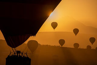 Sunrise in Cappadocia with hot air balloons in silhouette