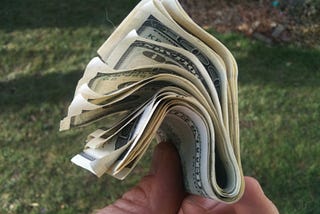 A wad of $100 bills held by the author.
