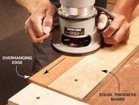 Woodworker holding a router on the edge of a board