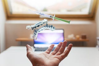 Syringe Floating Near Person’s Hand [Daniel Frank]