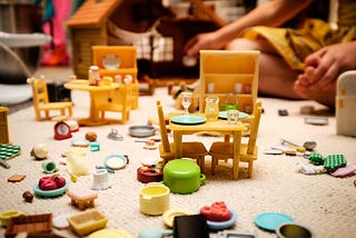 A jumble of toy kitchen items strewn on a carpet.