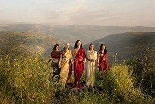 A photography of five women representing the daughters of Zelophehad on a grassy hill.