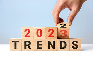 A hand changing a wooden blocks of words from 2022 to 2023 trends