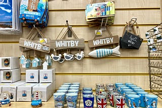 A variety of gifts such as snowglobes and glasses in a seaside gift shop.
