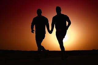 Gay men walking in the sunset.