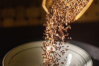 Flaxseed flowing into a bowl