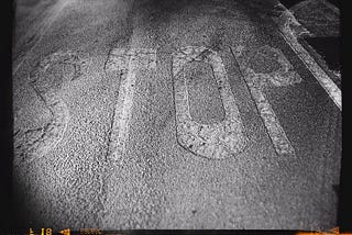 STOP written on pavement in black and white.