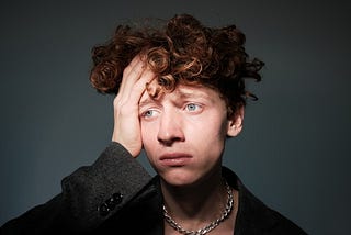 Worried boy with hand on his head, looking anxious