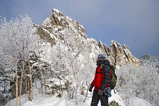 Mountain Climber looking up at a snow-covered mountain