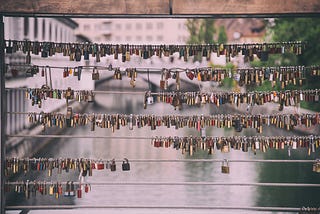 Padlocks hanging from a bridge railing as a representation of the union between couples.