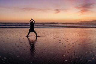 Sunset on the beach. Doing a Yoga and meditation pose