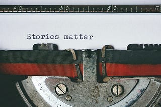 Close up shot of a typewriter with a sheet of paper where the words “Stories matter” have been typed on an otherwise blank page.