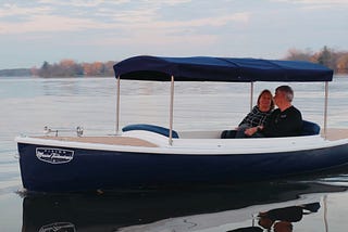 Two individuals enjoying a peaceful jaunt on their Quietude 156 electric boat.