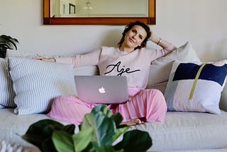 A photo of Mia Fileman leaning back on a couch with a laptop.