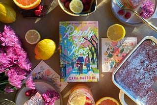 A photo of the book Ready or Not by Cara Bastone surrounded by citrus, raspbery lemon bars, and pink-purple flowers.