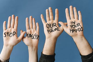 All Forms of Resistance.jpg in Canva Files folder] Four hands raised in the air with Stop Fascism Our Future In Your Hands written on them.