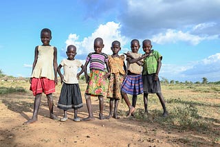 A group of Ugandan children standing in a field.