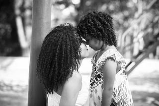 B/W photo of a mother and daughter snuggling nose to nose.