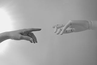 The picture has a human hand interacting with a robot hand. The human hand represents the natural language and creativity of humans, while the robot hand represents the artificial intelligence and computation of Large Language Models. The picture shows how human and AI can work together to achieve amazing results.