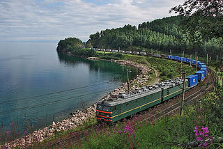 File: VL 85–022 container train.jpg English: BoBoBo+BoBoBo VL85 class AC electric locomotive VL85–022 with a container train on the coast of Lake Baikal, Trans-Siberian Railway: the stretch between Utulik-Slyudyanka. Author Sorovas This file is licensed under the Creative Commons Attribution-Share Alike 3.0 Unported license. https://creativecommons.org/licenses/by-sa/3.0/deed.en https://commons.wikimedia.org/wiki/File:VL_85-022_container_train.jpg