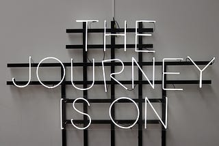 A picture with the text “THE JOURNEY IS ON”