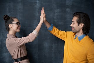 A man and woman high-fiving.