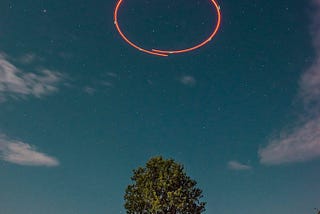 Long exposure of a drone circling on top of a tree in my backyard