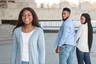 A woman walk's past a man and attracts his attention as he holds his girls hand. Love, relationships, cheating