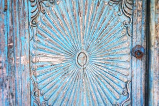 Image of an old wooden carving with faded blue paint.