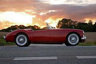 A red sports car in a sunset