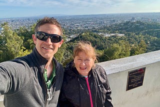 Mother and son standing in front of scenic rooftop background