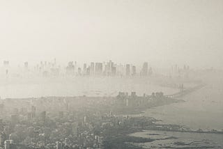 A stylized picture of the city of Mumbai from an airplane with thick smog settled over the bay