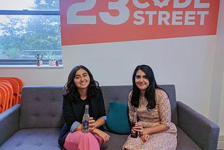 Anisah and Serena posing on the sofa with karma kola bottles