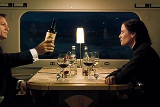 James Bond (left) pouring wine on a date in a train