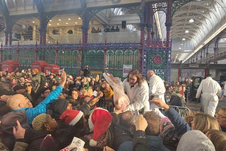 Butcher selling an entire leg of pork at a crowded event in Smithfield Market.