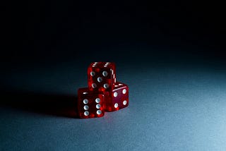 Picture of three red dice against a dark blue background.