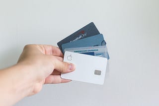 Hand holding credit cards against a white background.