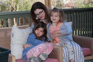 The author holds her daughters on her back deck.