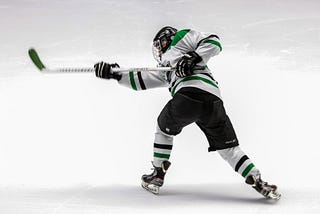 Ice hockey player takes a shot.