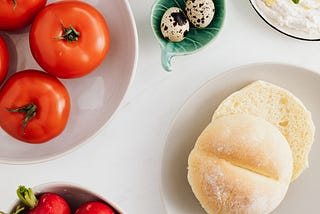 A table with vegetarian food- tomatoes, breads, etc