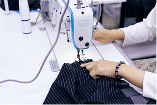 A person sewing a piece of clothing.