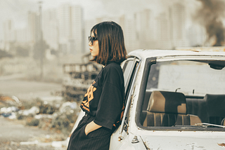 A girl dressed in black, staring at the debris.