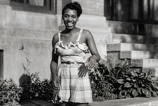 Black and white photo of a Black young woman in the fifties wearing a summer dress.