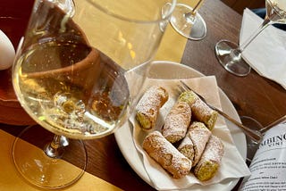 a vineyard tasting of white wine and delicious canoli on a table