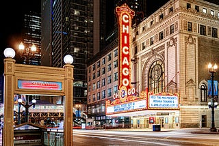 Chicago Theater and subway stop lit up with neon lights at night