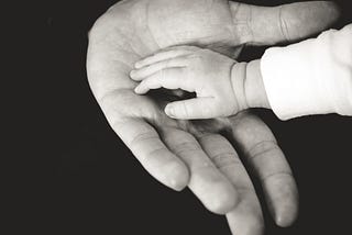 Father and child holding hands.