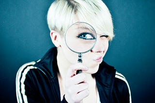 Picture of a woman looking through a magnifying glass