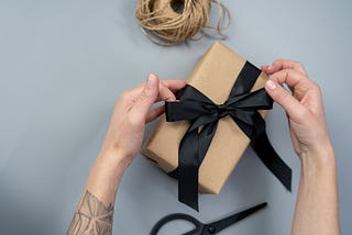 Photo of person tying a bow on a present.